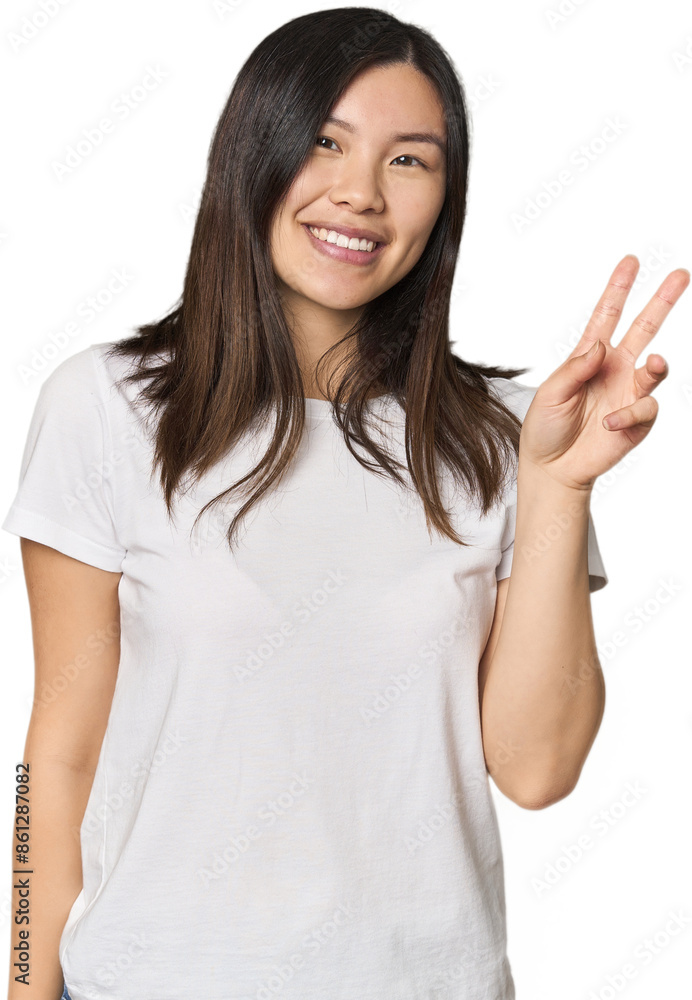 Young Chinese woman showing victory sign and smiling broadly. Young Chinese woman showing victory sign and smiling broadly.