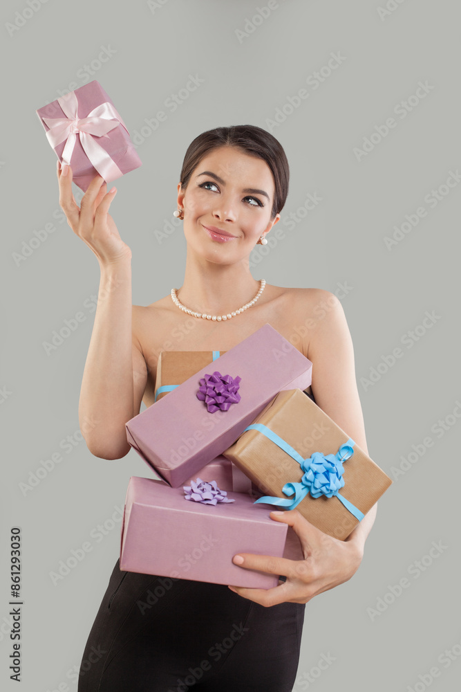 Happy brunette woman holding gift box and looking at pink present on white background. Happy brunette woman holding gift box and looking at pink present on white background.
