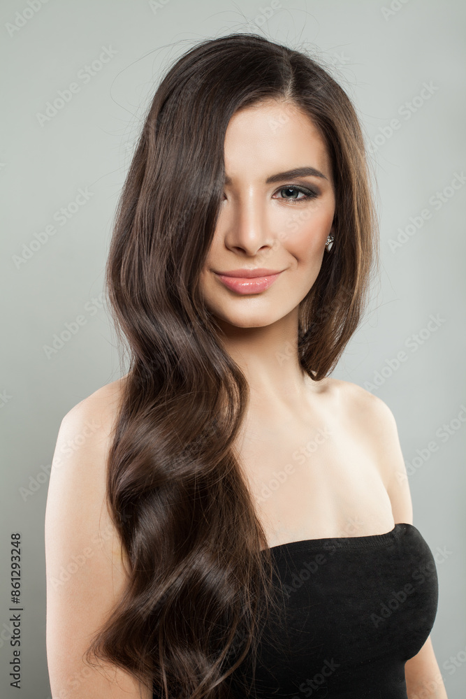 Naklejka premium Glorious young adult model woman with long healthy hairstyle, fresh shiny clear skin and makeup posing on white background. Beautiful female face close up