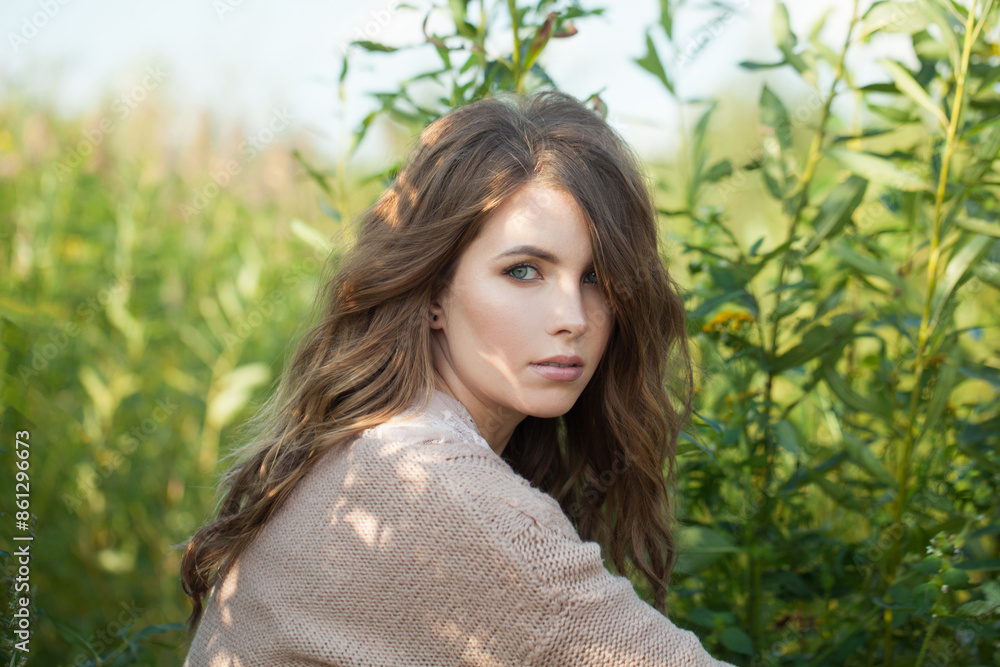 Cheerful healthy young model woman with clean fresh skin, natural make-up and curly hairstyle against green grass background, outdoor portrait Cheerful healthy young model woman with clean fresh skin, natural make-up and curly hairstyle against green grass background, outdoor portrait