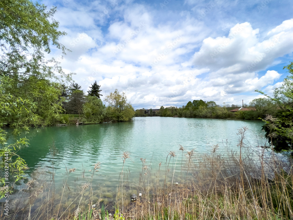 Obraz premium A large body of water is enclosed by trees on a cloudy day