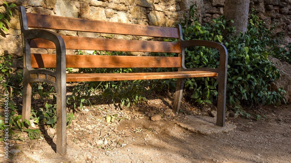 wood and metal bench in the park with sunlight in spain