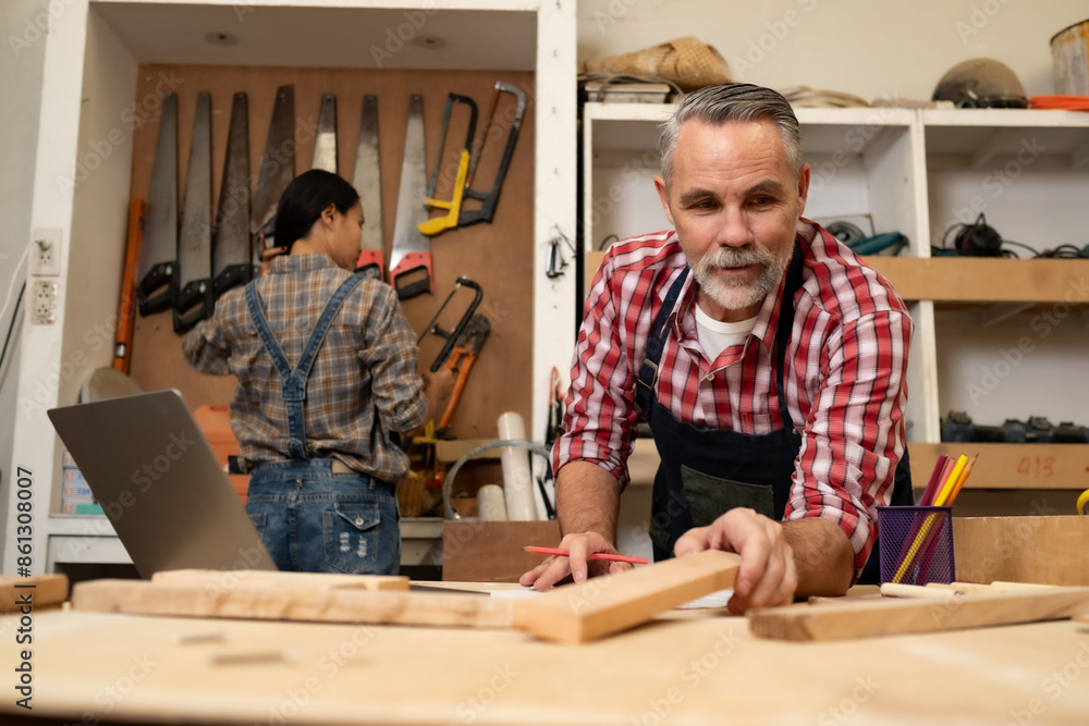 Senior Carpenter man working with his co-worker in furniture , working with piece of wood and tablet. Senior Carpenter man working with his co-worker in furniture , working with piece of wood and tablet.