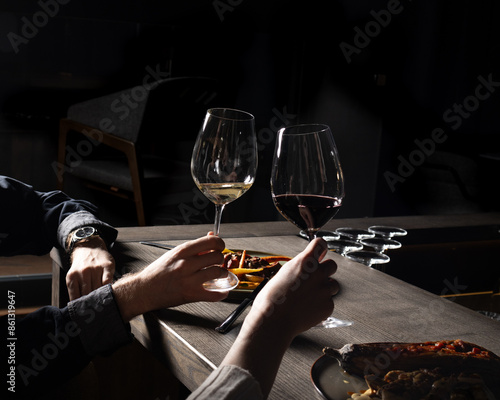 Couple enjoys romantic evening with wine and meal at dimly lit restaurant