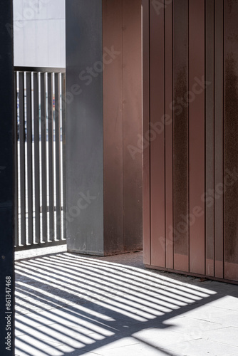 An intriguing architectural scene highlighting the interplay of light and shadows created by the metal bars, invoking a modern chiaroscuro effect within an urban setting.