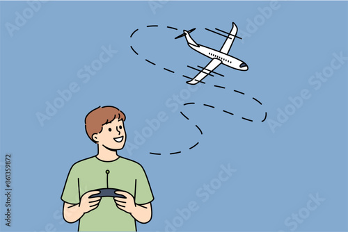Little boy uses radio-controlled airplane and smiles, rejoicing at appearance of new toy. Happy boy with remote control for playing with aircraft, dreams of becoming pilot when grows up