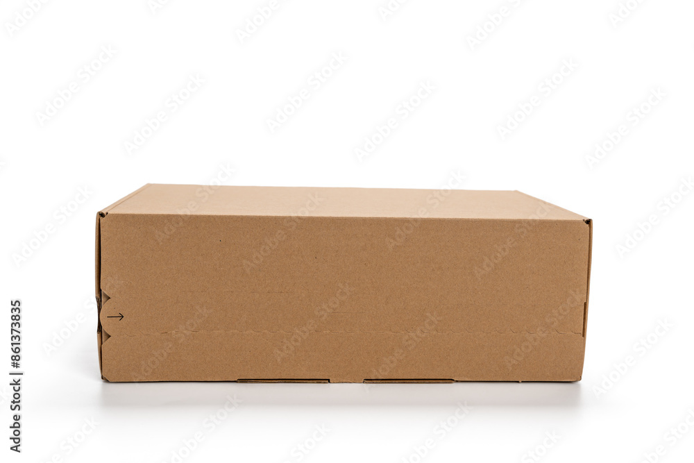 A cardboard box is sitting on a white background. The box is empty and has a brown color A cardboard box is sitting on a white background. The box is empty and has a brown color