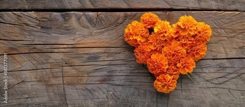 Heart-shaped Marigold arrangement on rustic wood with copy space image.