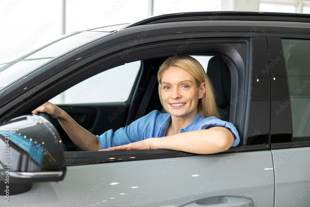 Blonde woman in a blue shirt in a new car Blonde woman in a blue shirt in a new car