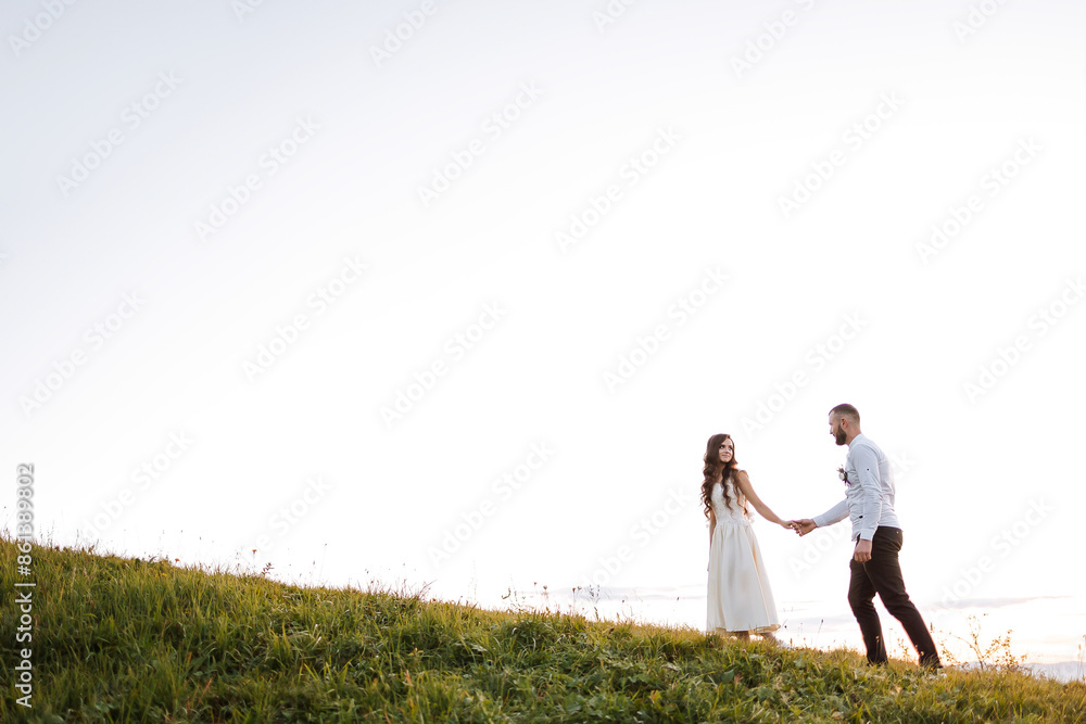 A couple is walking on a grassy hillside, hand in hand. The scene is peaceful and romantic, with the couple enjoying each other's company in a beautiful natural setting A couple is walking on a grassy hillside, hand in hand. The scene is peaceful and romantic, with the couple enjoying each other's company in a beautiful natural setting