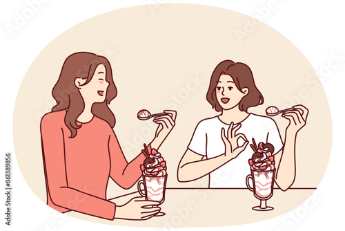 Women having lunch sitting in restaurant eating milkshake and discussing personal lives or plans for weekend. Girlfriends eat ice cream or milkshake in cafe wanting to cool off in hot summer weather