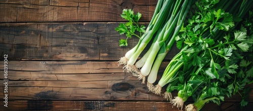 A top-down shot showing green onion, leek, and parsley on a wooden table, illustrating the concept of healthy eating with copy space image available. photo
