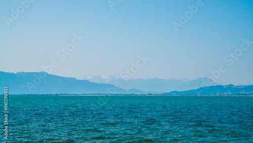 Obraz na płótnie Germany, Snow covered mountains nature landscape behind water of bodensee lake, panorama view from lindau to swiss and austrian coast on misty day w salonie