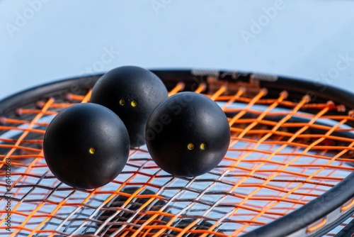 Squash balls on the background of a squash racket with a mirror image. Squash equipment for game. photo