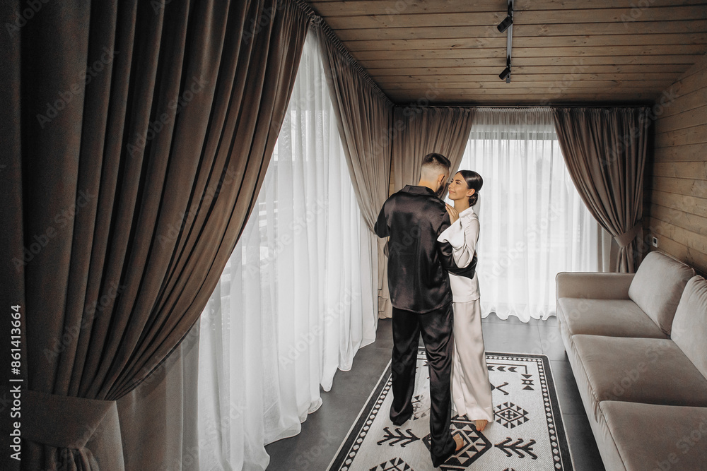 A man and woman are dancing in a room with white curtains and a rug. Scene is romantic and intimate A man and woman are dancing in a room with white curtains and a rug. Scene is romantic and intimate