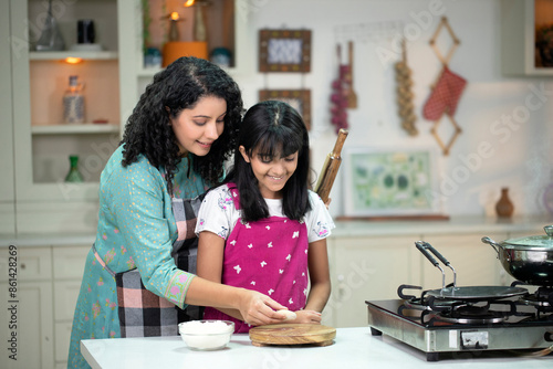 Mother And Daughter Cooking In Kitchen