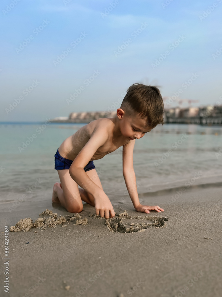 A boy plays in the sand on the beautiful atmospheric La Mer beach in Dubai, 2024