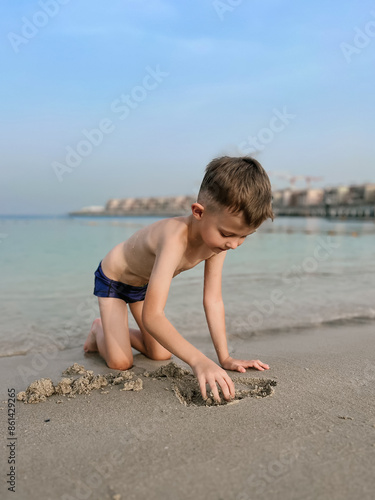 Obraz na płótnie A boy plays in the sand on the beautiful atmospheric La Mer beach in Dubai, 2024 w salonie