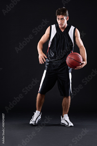 Sport, basketball player and man in studio with training, workout or practicing for game. Activity, career and male athlete with fitness equipment for match or exercise isolated by black background.