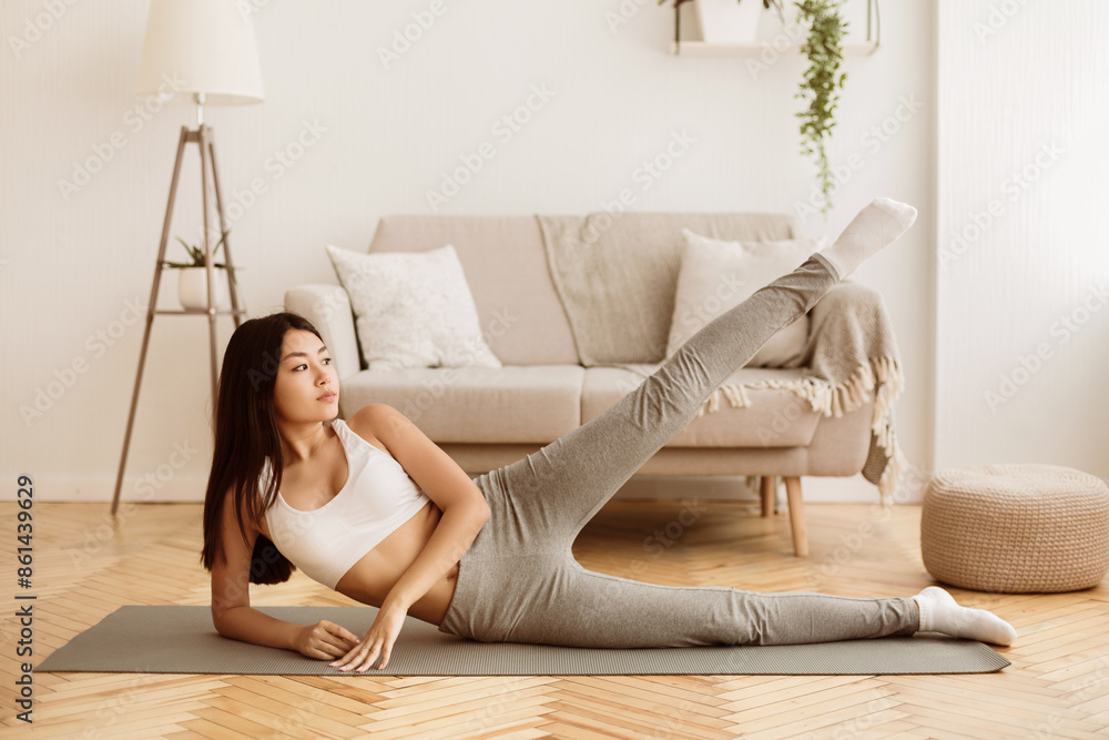 Home Fitness. Teenage Girl Doing Exercise For Legs on Floor in Living Room Home Fitness. Teenage Girl Doing Exercise For Legs on Floor in Living Room