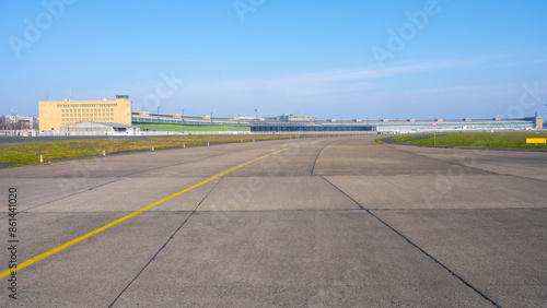 Bild auf Leinwand Clear blue skies over the historic Berlin Tempelhof Airport in Germany, showcasing the vast airport tarmac and iconic terminal building with hangars