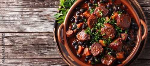 A top view of the traditional Brazilian dish Feijoada with black beans, pork, and sausage, allowing for copy space in the image.