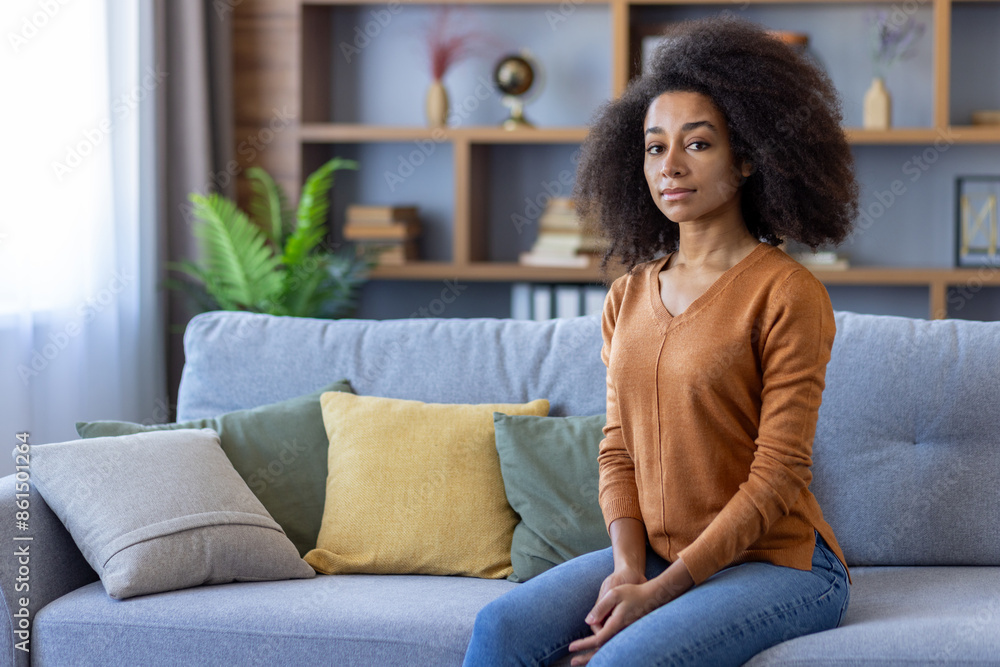 Confident young woman sitting on couch in modern living room with stylish decor. Relaxed and calm atmosphere. Natural light creating cozy ambiance. Confident young woman sitting on couch in modern living room with stylish decor. Relaxed and calm atmosphere. Natural light creating cozy ambiance.