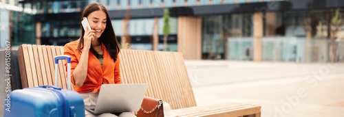Always In Touch. Happy Woman Traveler Talking On Mobile Phone While Working Online On Laptop Computer, Waiting For Flight Near Modern Airport Outside, Sitting With Suitcase, Copy Space