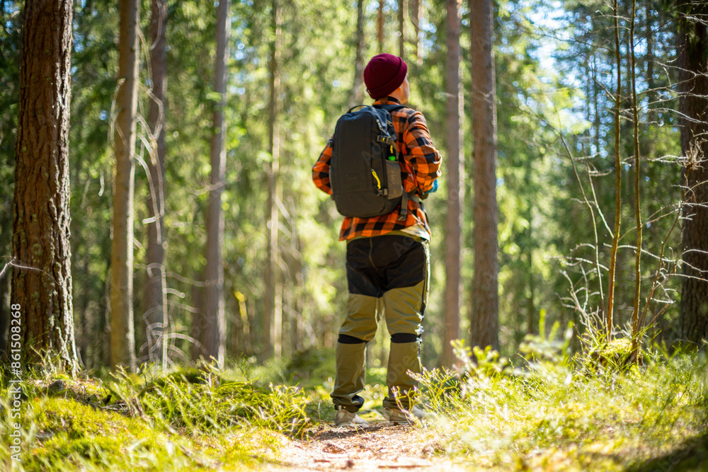 male hiker standing in a middle of a forest and enjoying the scenery male hiker standing in a middle of a forest and enjoying the scenery