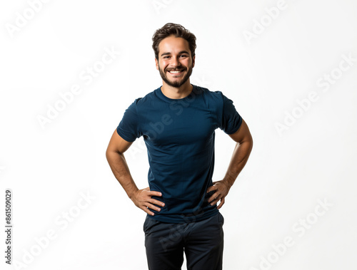 20s Latino man, he is standing with his hands on his hips wearing a blue t-shirt, positive and smiling, isolated on a white background. 