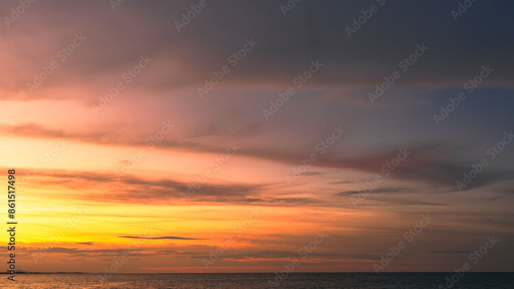 Sunset sky clouds over sea in the evening with orange, yellow gold sunlight in golden hour and dramatic fluffy, Horizon sea sky landscape, dusk sky background Sunset sky clouds over sea in the evening with orange, yellow gold sunlight in golden hour and dramatic fluffy, Horizon sea sky landscape, dusk sky background