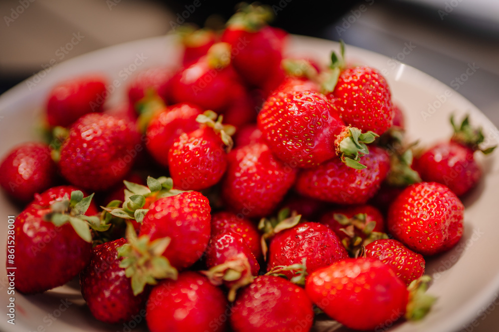A close-up of fresh, ripe strawberries piled in a bowl, showcasing their vibrant red color and green leaves. A close-up of fresh, ripe strawberries piled in a bowl, showcasing their vibrant red color and green leaves.