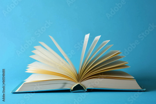 Open Book with Flipping Pages Isolated on Blue Background: Concept of Knowledge, Education, Literature, and Learning Resources © Nadezhda