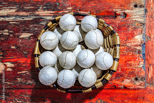 Wallpaper Mural A basket filled with Basque pelota balls on a rustic wooden surface. Torontodigital.ca