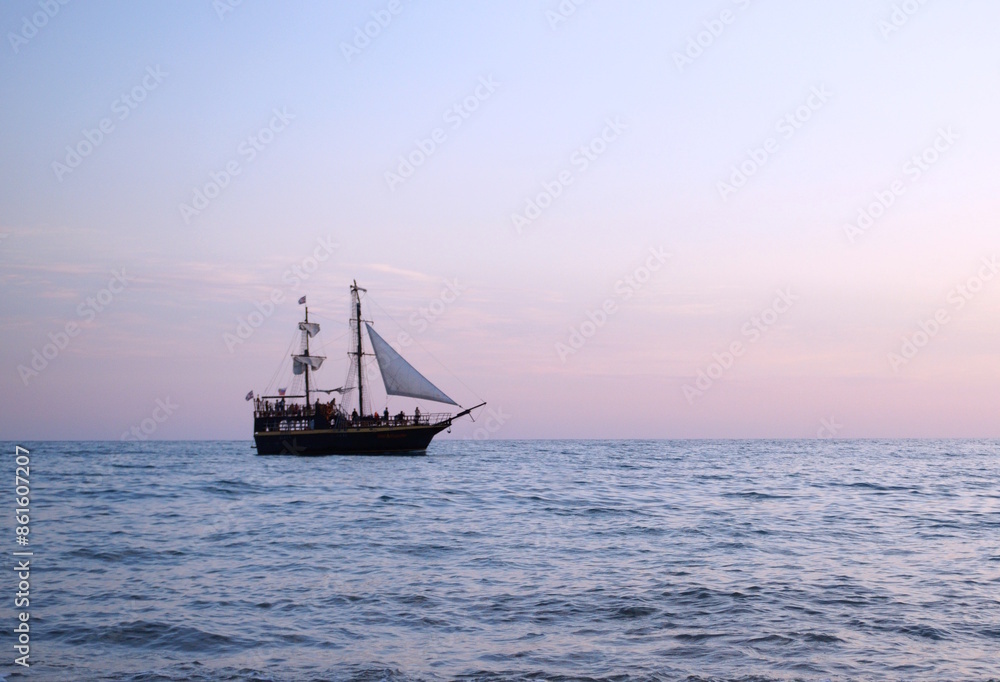 A ship with a sail is sailing on the sea. A ship with a sail is sailing on the sea.