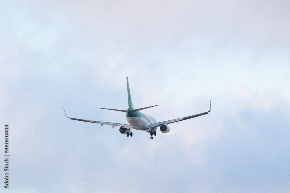 Obraz premium White passenger airplane flying in the sky amazing clouds in the background