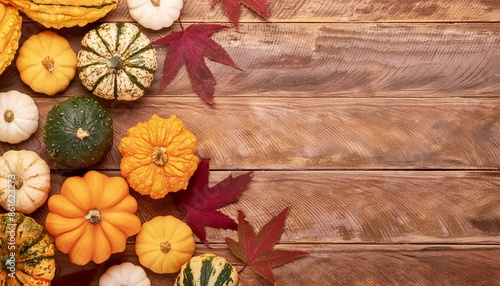 Pumpkins and Fall leaves on wooden table with blank space.