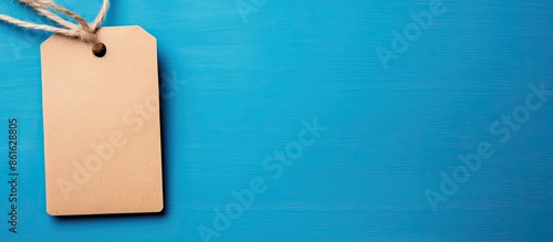 String-tied brown paper tag with copy space image on blue backdrop. photo