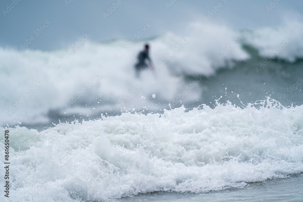 Naklejka premium Surfer in the Mist of Ocean Waves