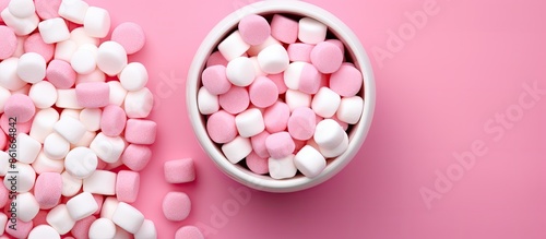 Top view of white and pink candy displayed in a white jar against a pink background with open space that can be utilized for images or text. with copy space image. Place for adding text or design