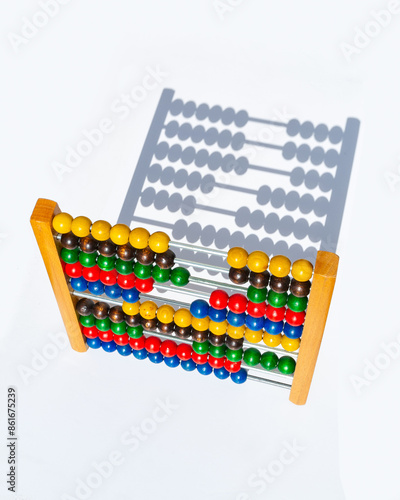 children wooden abacus with multicolored counters casting shadow on white background photo