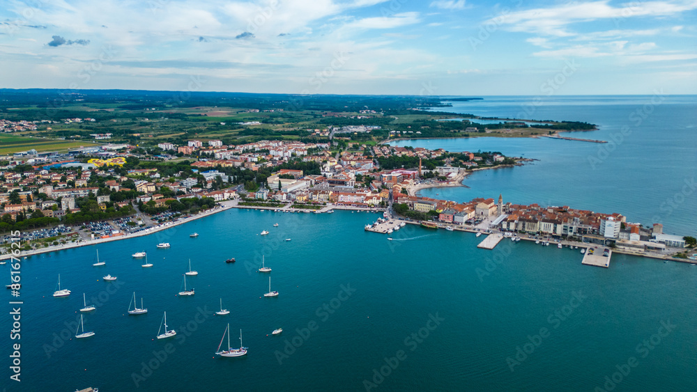 Fototapeta premium A stunning aerial view of Umag, a charming coastal town in Istria, Croatia. Known for its beautiful beaches, historic architecture, and vibrant marina, Umag offers a perfect blend of relaxation
