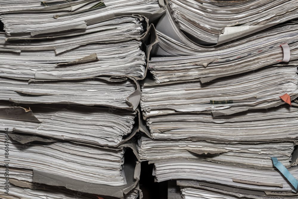 Paper documents stacked in archive. folders with documents on the shelves of archive room. Office shelves in the closet full of files Paper documents stacked in archive. folders with documents on the shelves of archive room. Office shelves in the closet full of files