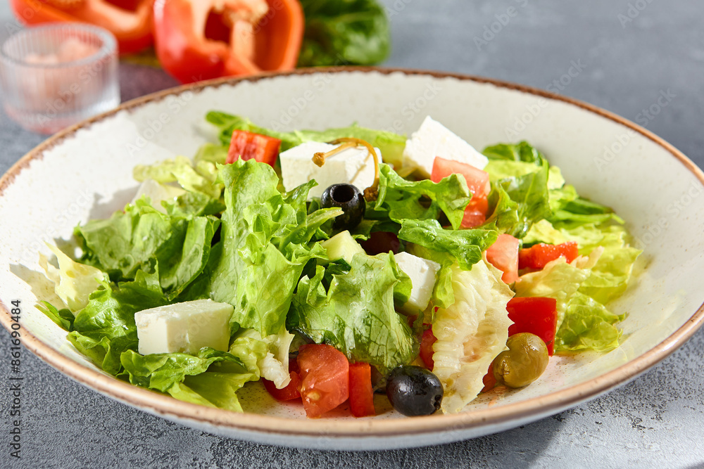 Greek salad with feta cheese and olives on a sunlit textured background Greek salad with feta cheese and olives on a sunlit textured background