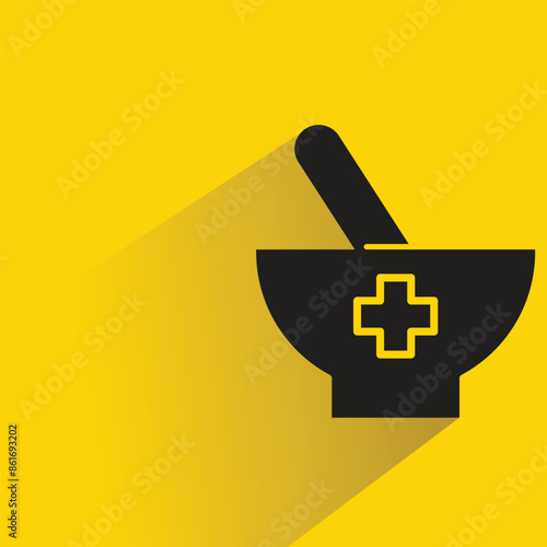 medicine mortar and pestle with shadow on yellow background