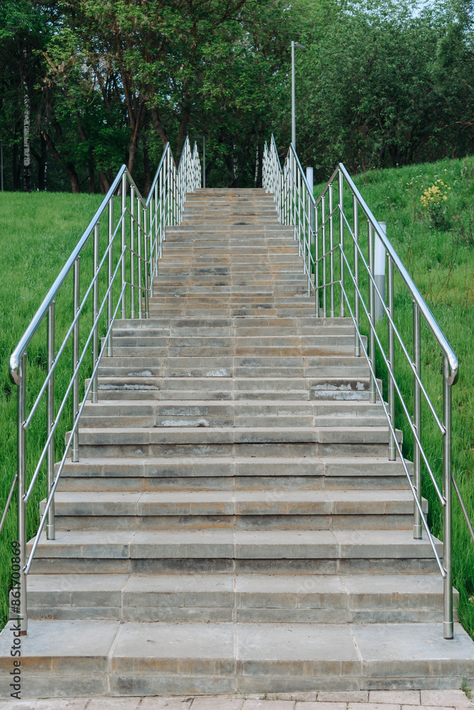 stone staircase with metal railings in city park in summer day, green grass on sides, place for walking and cardio training, no people, vertical photo stone staircase with metal railings in city park in summer day, green grass on sides, place for walking and cardio training, no people, vertical photo