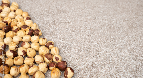 Roasted hazelnuts on a gray stone background top view, place for text