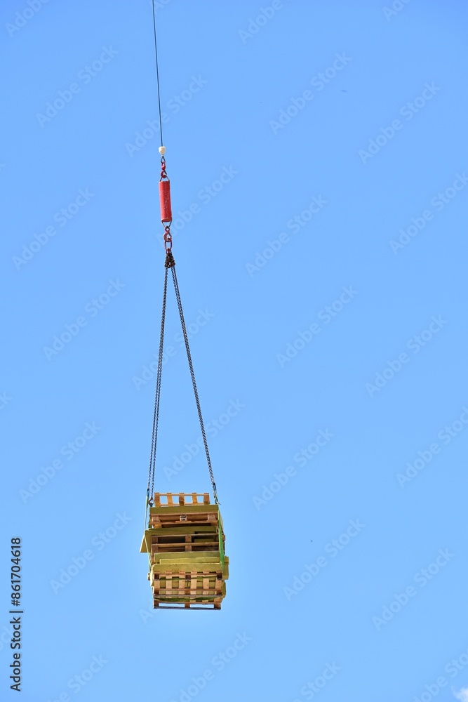 wooden pallets hanging against blue sky background wooden pallets hanging against blue sky background