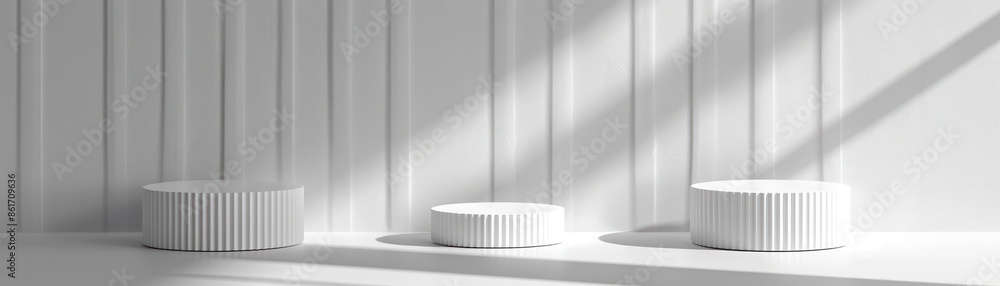 Minimalistic monochrome composition featuring three white round pedestals on a white background with gentle sunlight casting shadows. Minimalistic monochrome composition featuring three white round pedestals on a white background with gentle sunlight casting shadows.