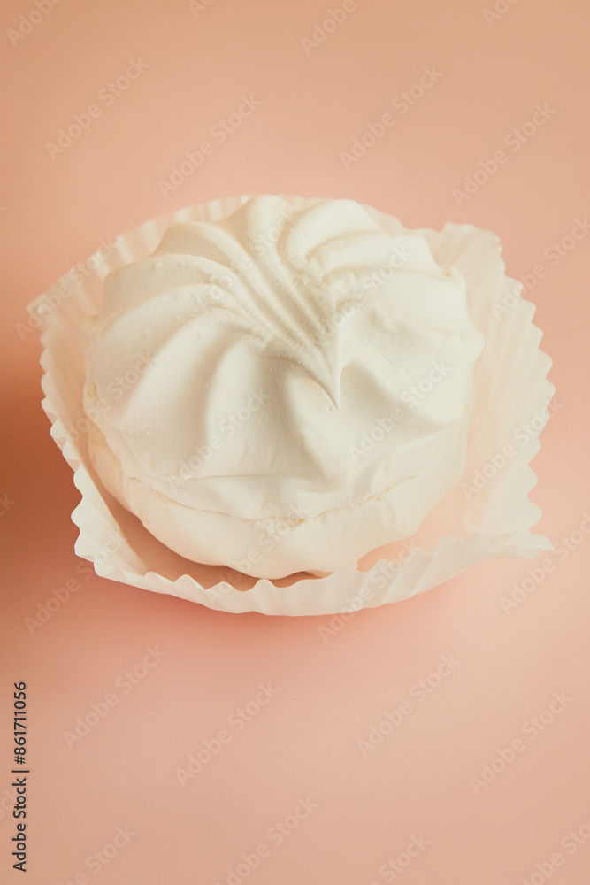 One marshmallow brownie in a white paper tartlet on a pink background vertical shot One marshmallow brownie in a white paper tartlet on a pink background vertical shot